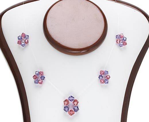 Crystal beads woven into round pendants on invisible cording, resting on a necklace form.